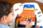 Hot Wheels - Rollout Raceway Trackset, lässt sich zu einer fünfspurigen Rennstrecke ausrollen, Aufbewahrungsbehälter, Spielzeug Autorennbahn für Kinder ab 4 Jahren – Bild 2